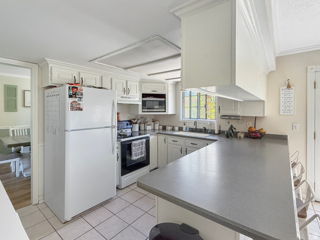 1716 Sagewood Road Price, UT 84501 - Photo 12 of 73 Kitchen with freestanding refrigerator, crown molding, a kitchen breakfast bar, range with electric stovetop, and a peninsula