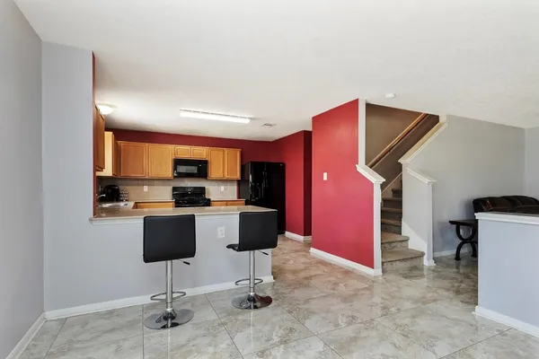 a living room with furniture a rug and kitchen view