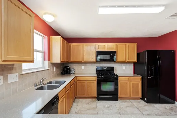 a kitchen with a sink a stove top oven and refrigerator