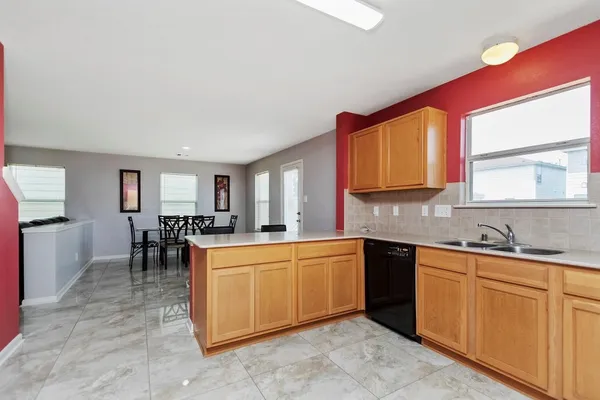 a large kitchen with cabinets a sink and appliances