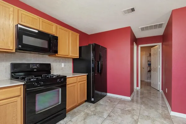 a kitchen with stainless steel appliances granite countertop a stove microwave and refrigerator