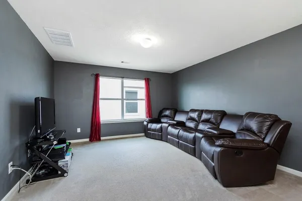 a living room with furniture a flat screen tv and a window