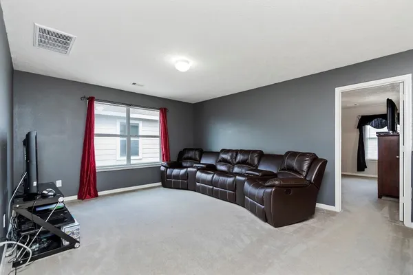 a living room with furniture a flat screen tv and a window