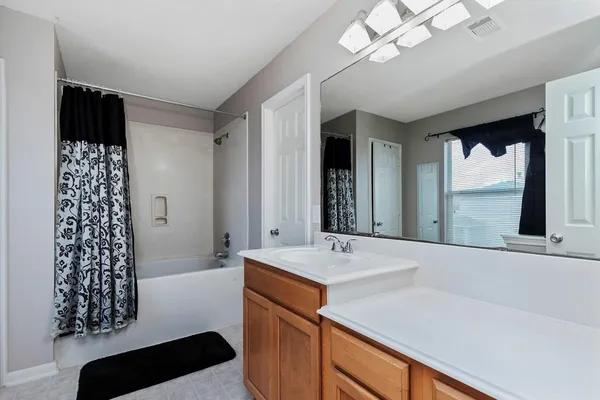 a bathroom with a sink a large mirror and a bathtub