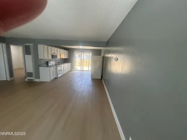 a view of a hallway with wooden floor and windows