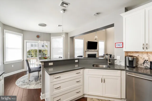 a kitchen with granite countertop white cabinets sink and dining table