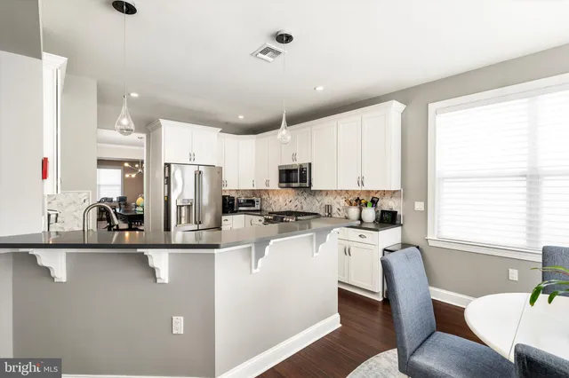 a kitchen with stainless steel appliances granite countertop a sink a stove and a refrigerator