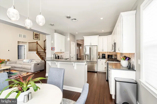 a living room with stainless steel appliances furniture and a chandelier