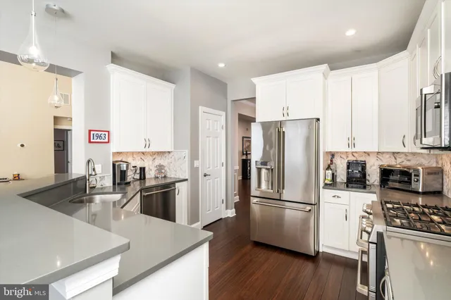 a kitchen with stainless steel appliances granite countertop a refrigerator stove and sink