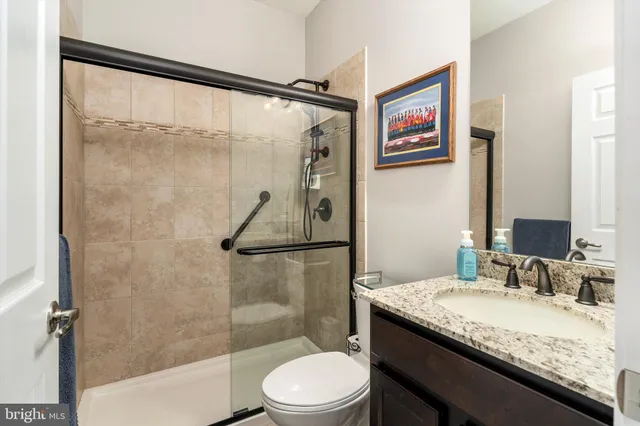 a bathroom with a granite countertop sink toilet and shower