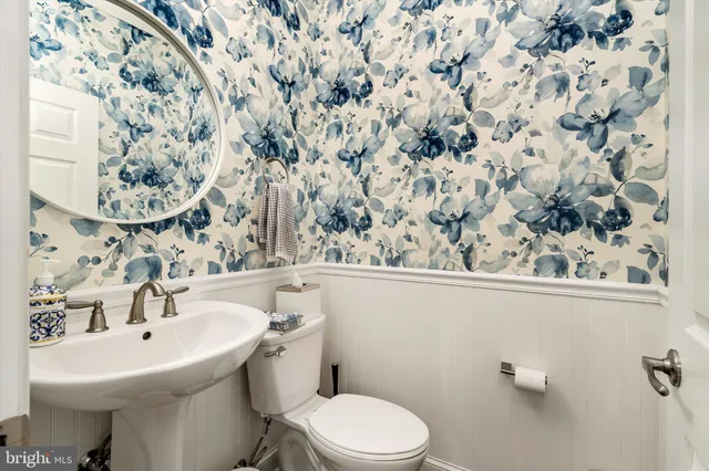 a bathroom with a sink and mirror with toilet