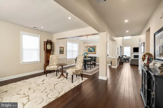 a living room with furniture a wooden floor and next to a window