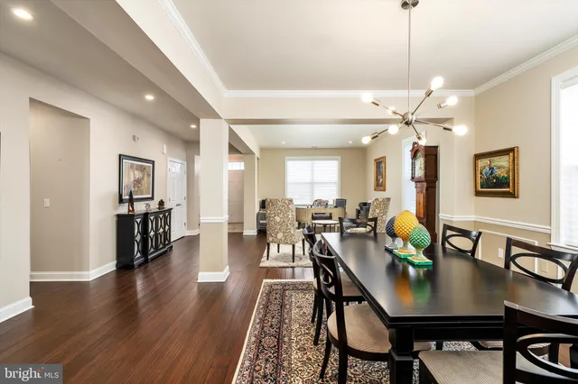 a view of a dining room and livingroom with furniture wooden floor a chandelier