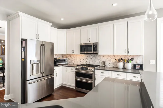 a kitchen with stainless steel appliances a refrigerator sink and microwave