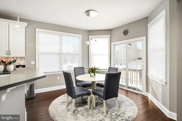 a dining room with furniture a chandelier and wooden floor