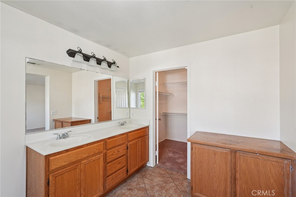 1793 Agrigento Avenue Riverside, CA 92507 - Photo 27 of 34 a spacious bathroom with a double vanity sink and a mirror