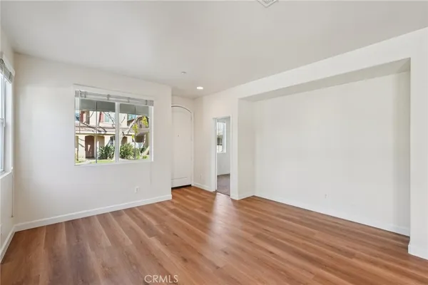 a view of a hallway with wooden floor and entryway