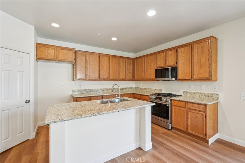 1793 Agrigento Avenue Riverside, CA 92507 - Photo 7 of 34 a kitchen with stainless steel appliances granite countertop a sink stove and cabinets