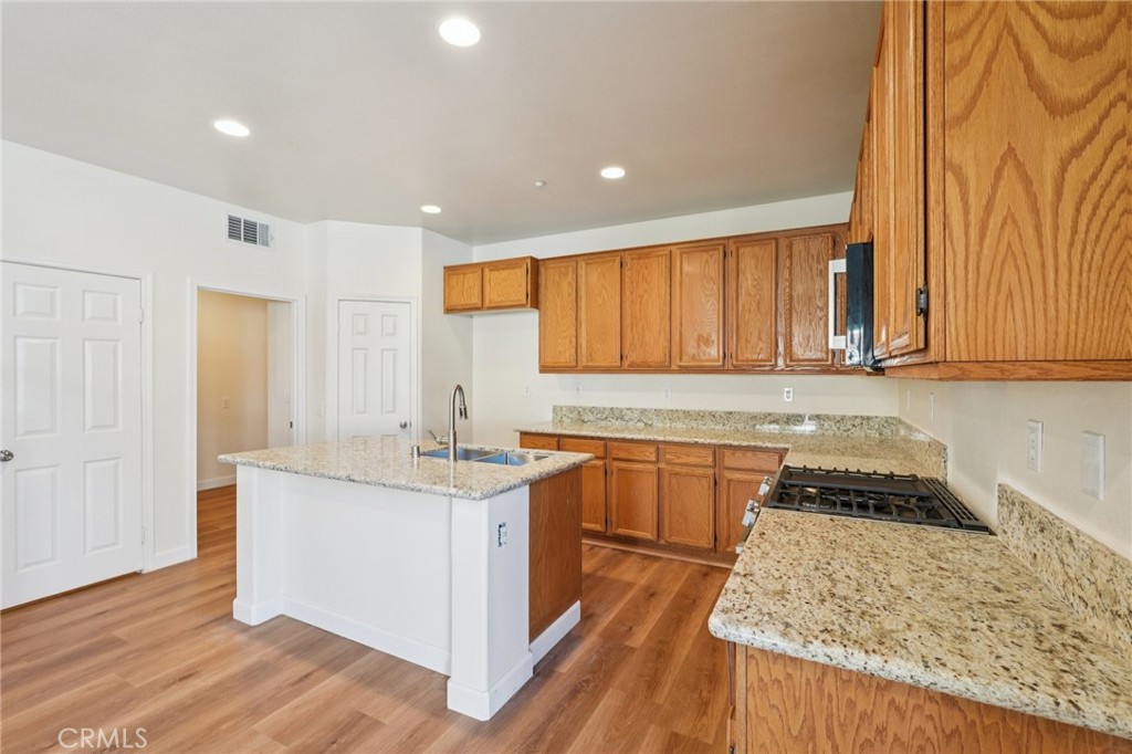1793 Agrigento Avenue Riverside, CA 92507 - Photo 8 of 34 a kitchen with stainless steel appliances granite countertop a stove a sink and a microwave