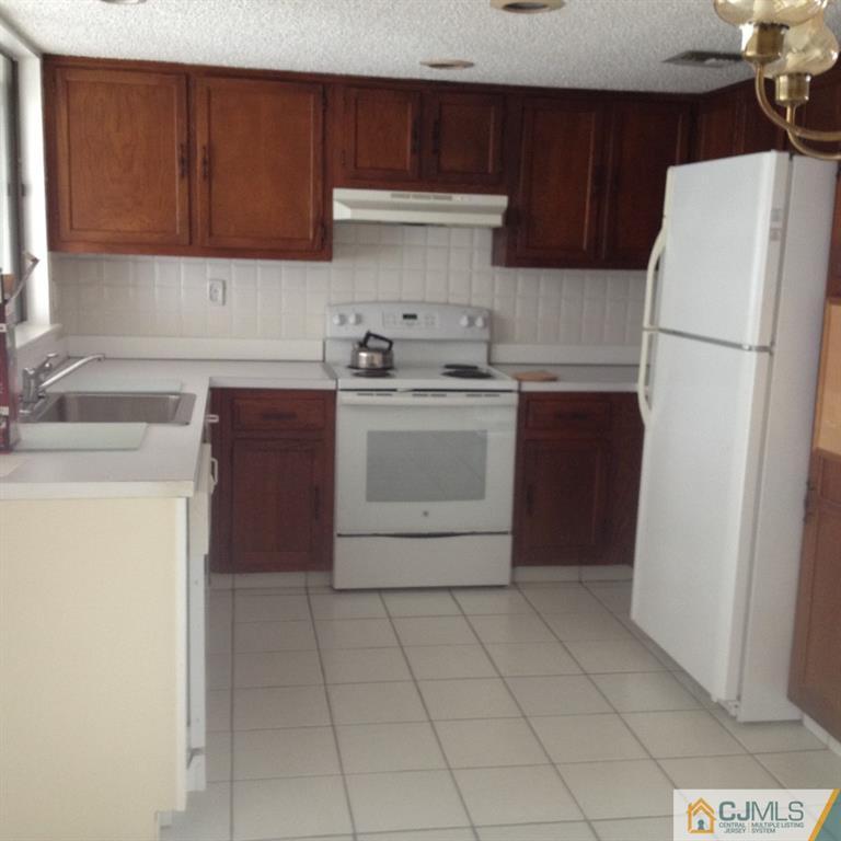 38 C Haddon Road Monroe Township, NJ 08831 - Photo 9 of 19 a kitchen with a stove sink and a refrigerator