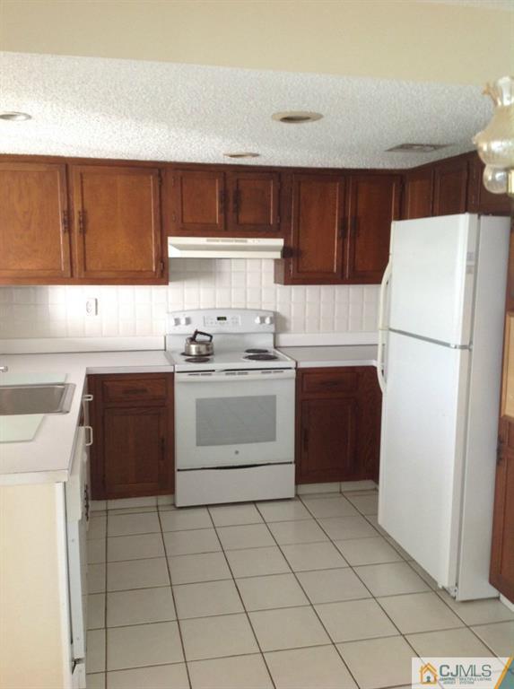38 C Haddon Road Monroe Township, NJ 08831 - Photo 10 of 19 a kitchen with a stove sink and a refrigerator