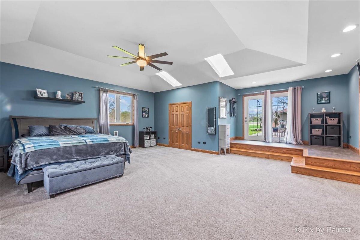 18570 Stevens Road Marengo, IL 60152 - Photo 17 of 45 a spacious bedroom with a large bed and a chandelier