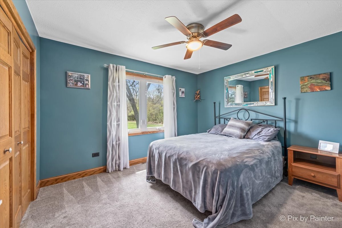 18570 Stevens Road Marengo, IL 60152 - Photo 23 of 45 a bedroom with a large bed and a chandelier