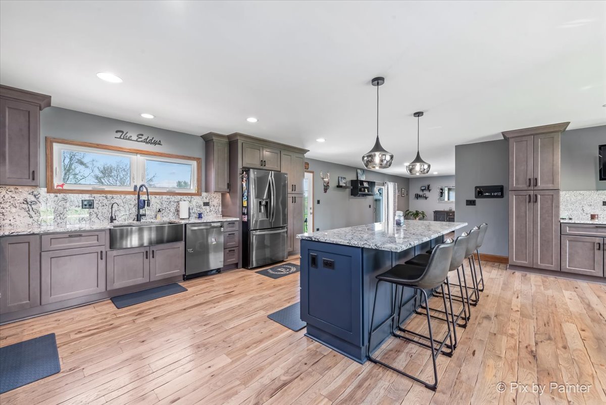 18570 Stevens Road Marengo, IL 60152 - Photo 8 of 45 a kitchen with stainless steel appliances kitchen island granite countertop wooden floors and view