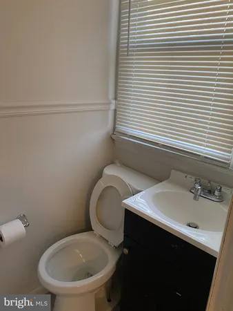 a bathroom with a toilet a sink and mirror