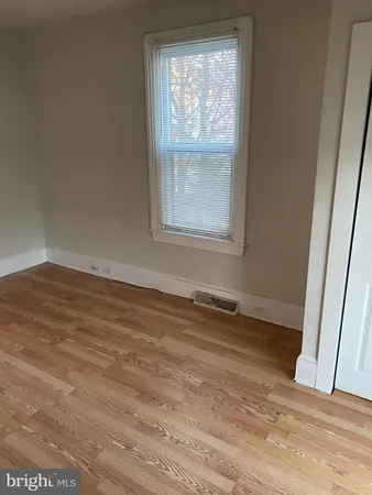 a view of a room with wooden floor and window