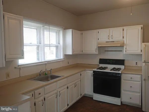 a kitchen with cabinets appliances a sink and a window