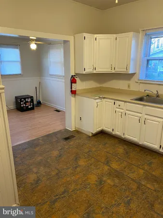 a kitchen with stainless steel appliances granite countertop a sink a stove and white cabinets