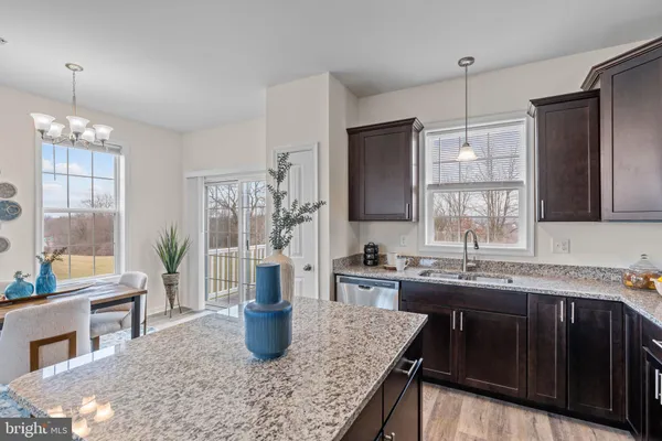 a kitchen with stainless steel appliances granite countertop a sink wooden cabinets and counter space