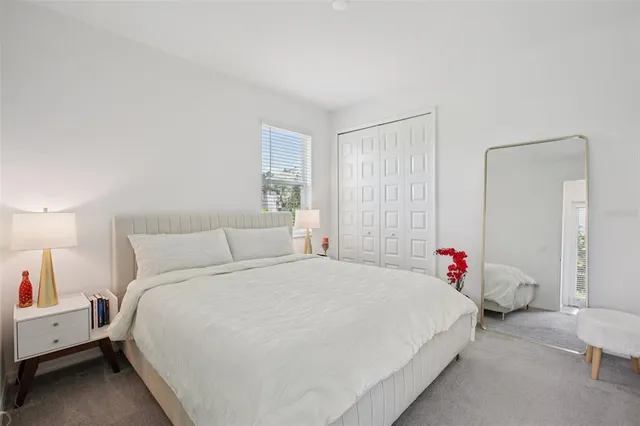 a bedroom with a bed and a potted plant