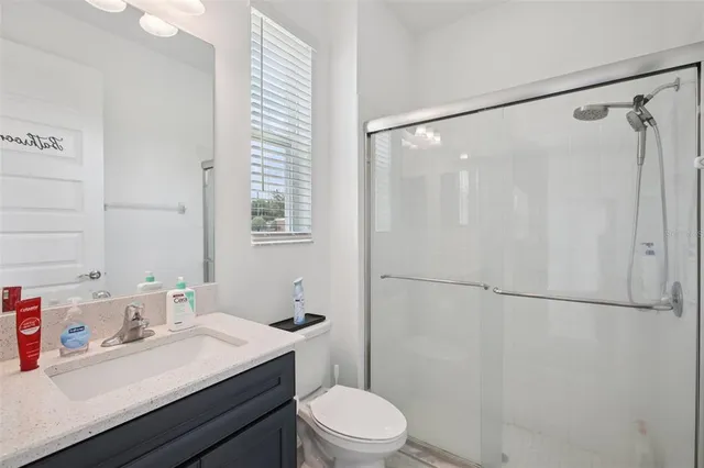 a bathroom with a sink vanity mirror and toilet