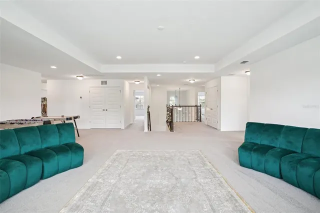 a living room with furniture and a refrigerator