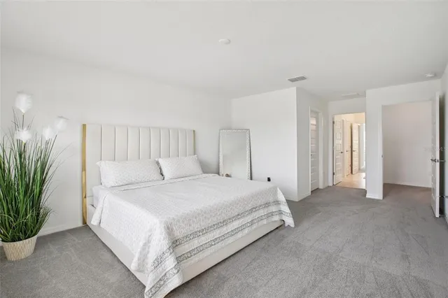 a large bed sitting in a room next to a window