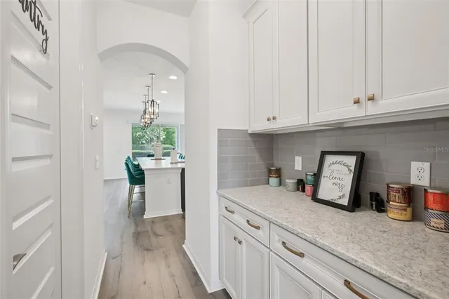 a kitchen with white cabinets and counter space