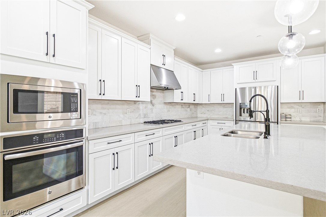 2182 Trivero Street Henderson, NV 89044 - Photo 17 of 50 Smooth stone countertops pair beautifully with crisp shaker cabinetry and modern built-in appliances.
