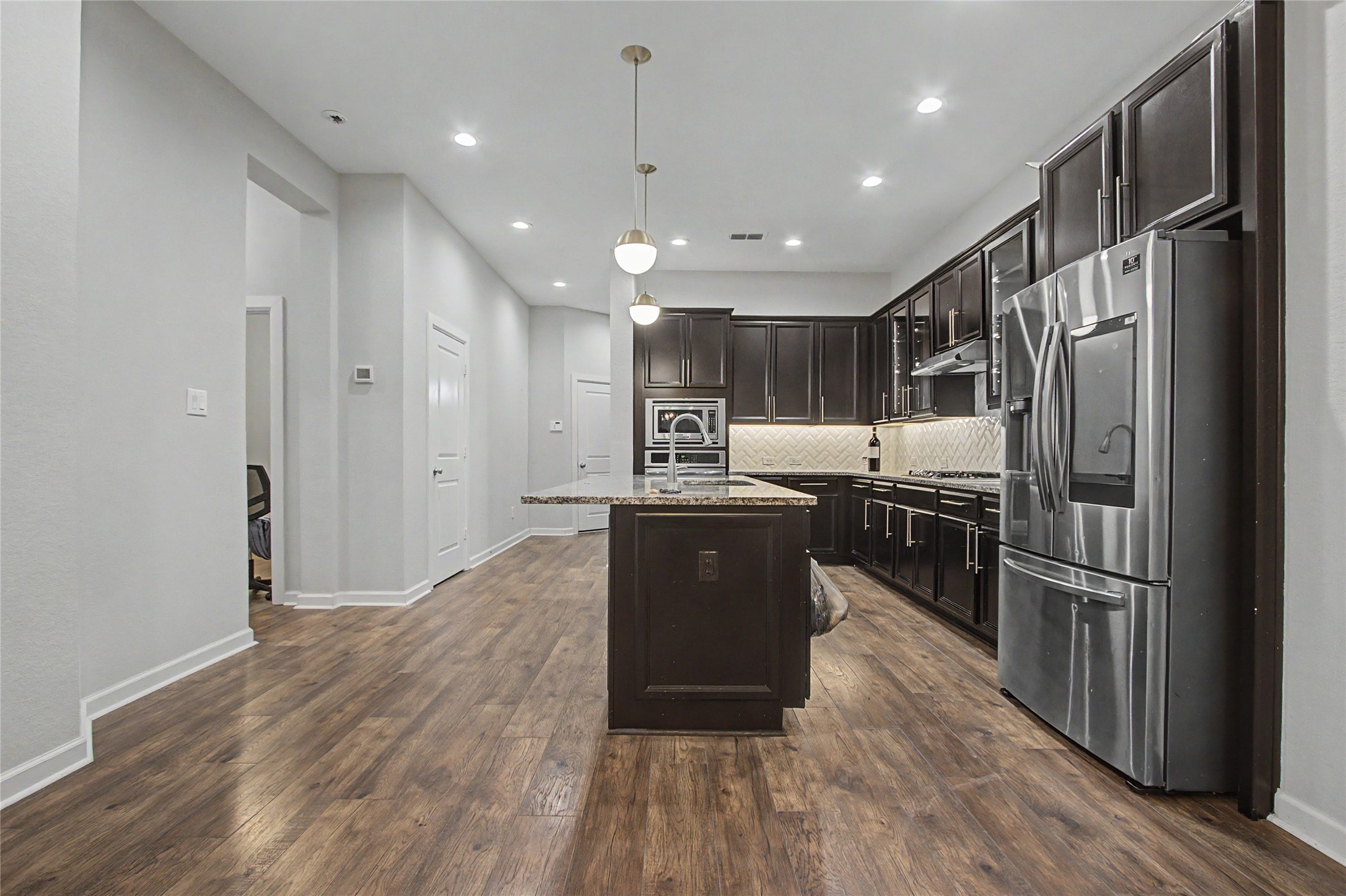 19718 Shinnery Ridge Court Cypress, TX 77433 - Photo 6 of 23 a kitchen with kitchen island wooden floors appliances and cabinets