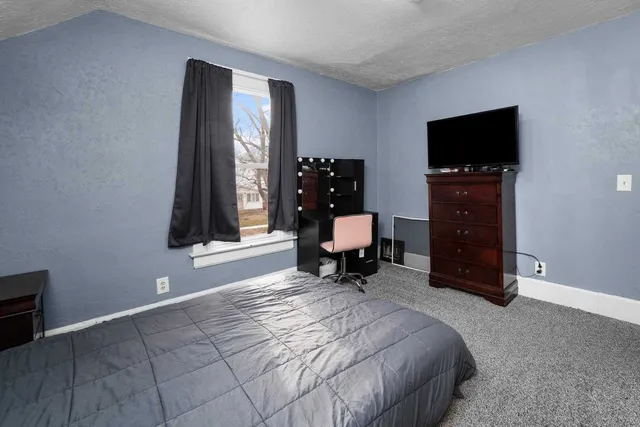 a bed room with a bed and a television