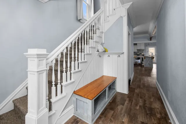 a living room with wooden floor and stairs