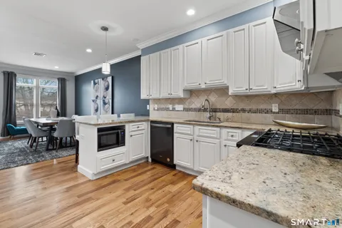 a kitchen with granite countertop white cabinets and white appliances
