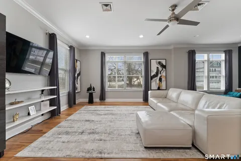 a living room with furniture a flat screen tv and a rug