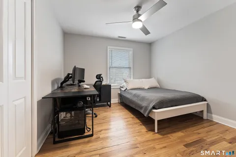 a bedroom with a bed and wooden floor