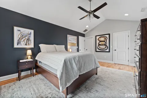 a bedroom with a bed painting on wall and a desk