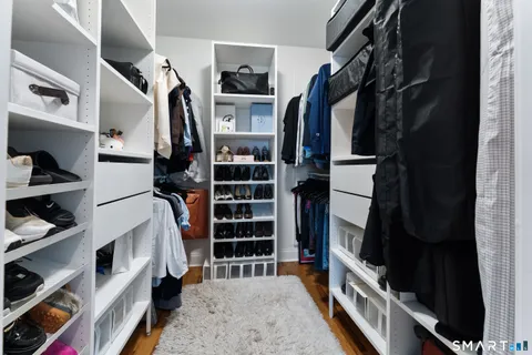 a view of walk in closet with clothes and shoes
