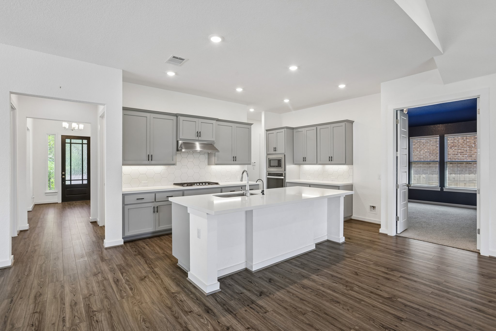 317 Independence Drive Kyle, TX 78640 - Photo 1 of 40 a large white kitchen with wooden floor and stainless steel appliances