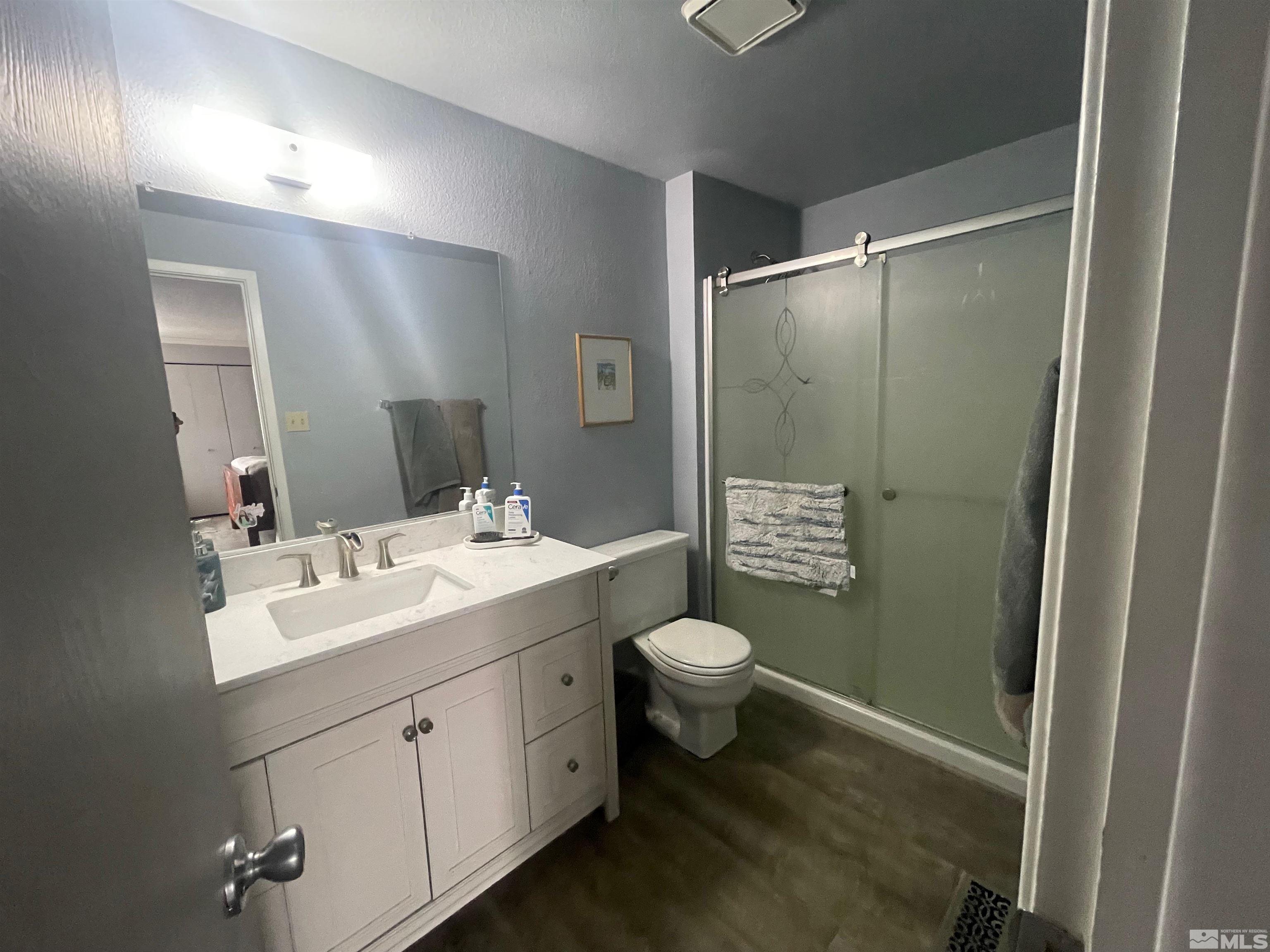 7550 Bluestone Drive Reno, NV 89511 - Photo 14 of 15 a bathroom with a sink toilet a mirror and shower