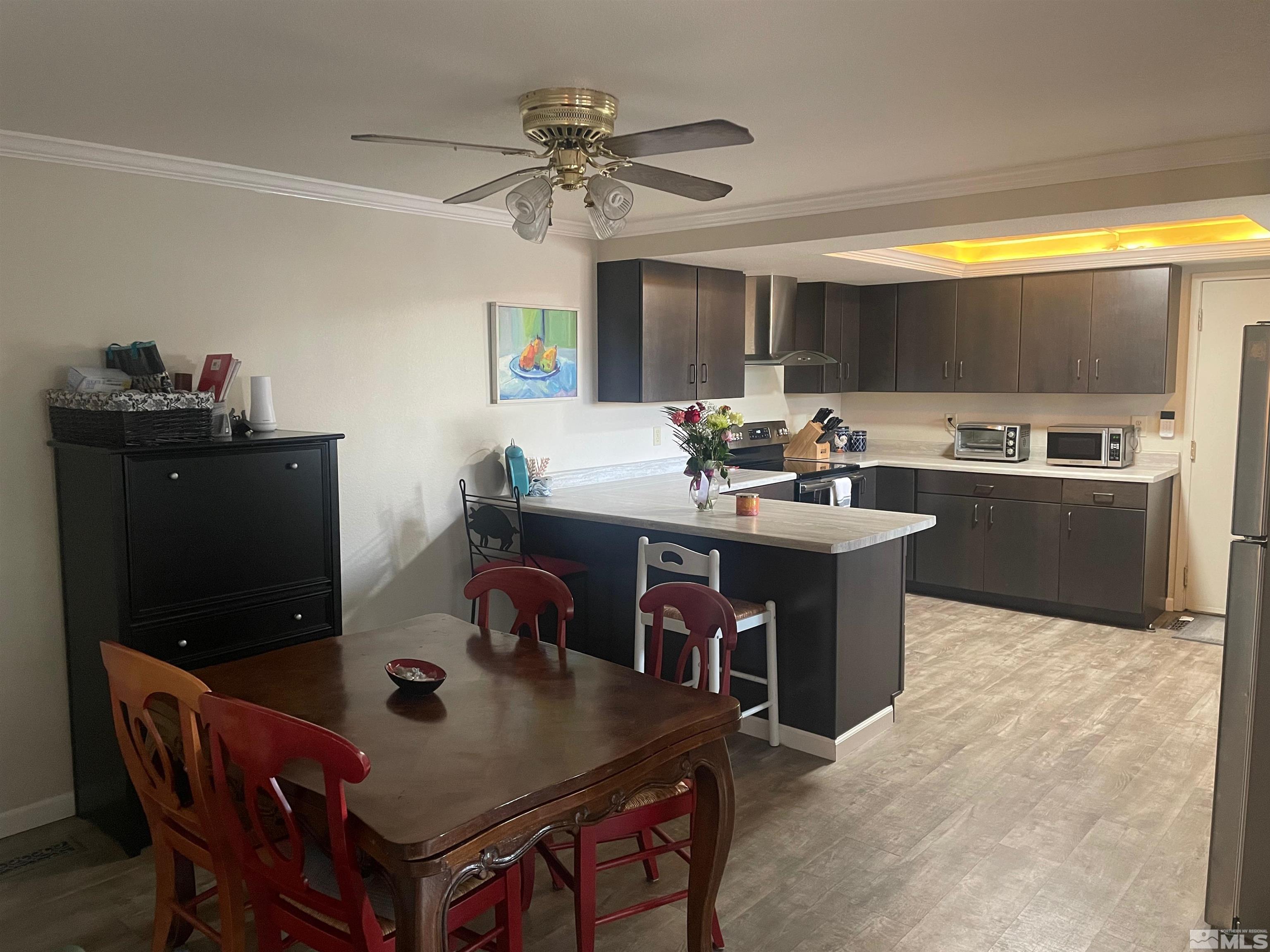 7550 Bluestone Drive Reno, NV 89511 - Photo 5 of 15 a kitchen with a stove a sink a kitchen island with a dining table and chairs